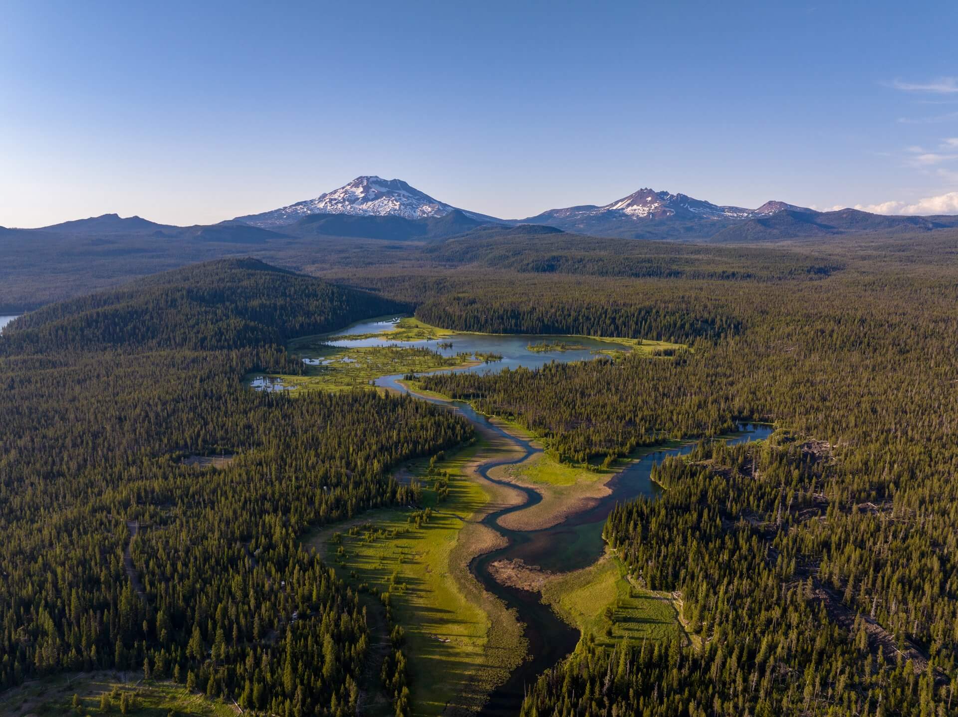 High Cascade lake reflecting volcanic peaks
