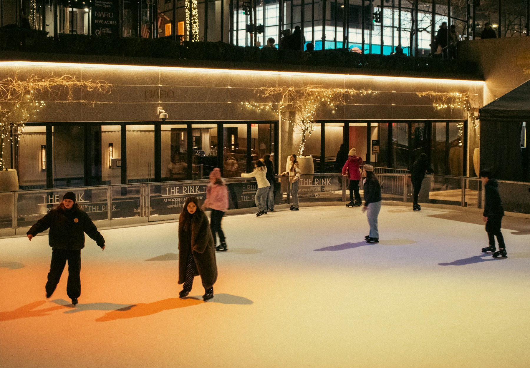 Outdoor ice skating downtown under string lights
